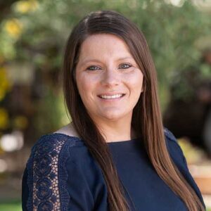 Photo of Sarah Anderson - a smiling woman with long hair in front of a backdrop of trees in soft focus